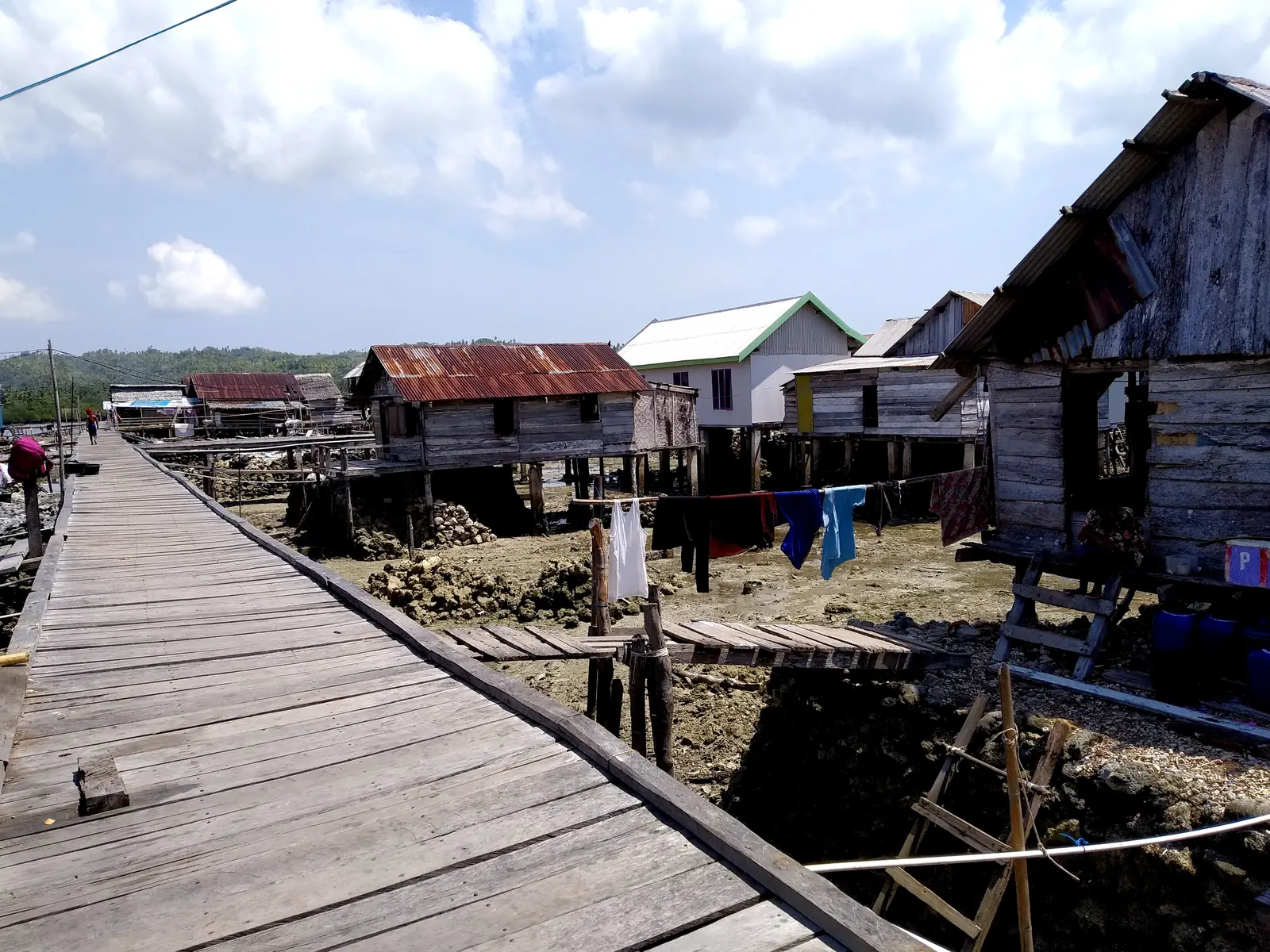Titian kayu di antara rumah panggung Desa Mantigola di Kaledupa saat air surut